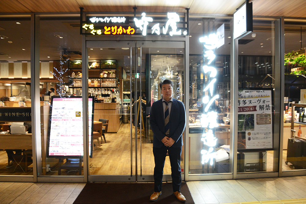 博多竹乃屋の店舗前に立つ株式会社タケノの濱田稔男様。給与業務のBPO化サービスnoncore導入により、担当者依存の課題を解消した事例インタビューより。